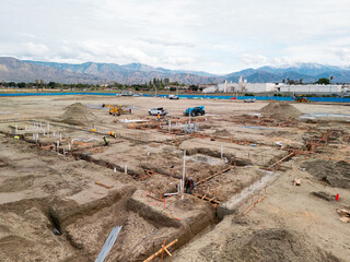 Aerial view of a large-scale construction site with heavy machinery and industrial building progress.ult