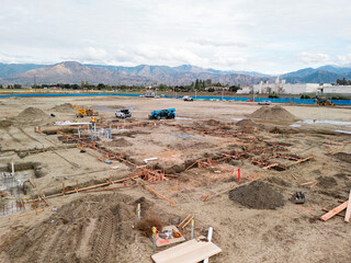 Aerial view of a large-scale construction site with heavy machinery and industrial building progress.ult