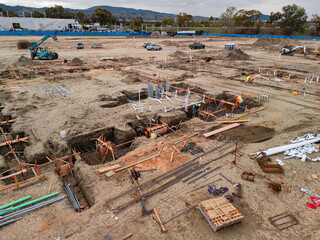 Aerial view of a large-scale construction site with heavy machinery and industrial building progress.ult