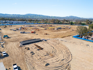 Aerial view of a large-scale construction site with heavy machinery and industrial building progress.ult