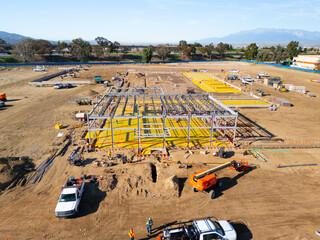 Aerial view of a large-scale construction site with heavy machinery and industrial building progress.ult