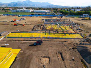 Aerial view of a large-scale construction site with heavy machinery and industrial building progress.ult