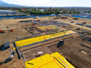 Aerial view of a large-scale construction site with heavy machinery and industrial building progress.ult