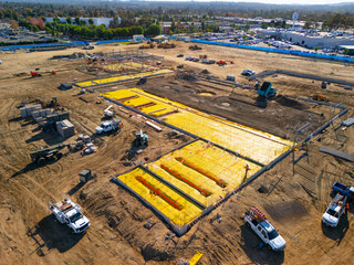 Aerial view of a large-scale construction site with heavy machinery and industrial building progress.ult