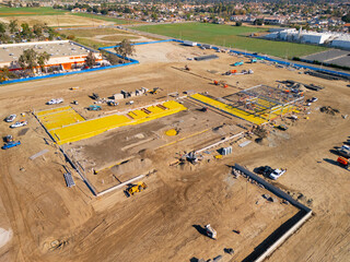 Aerial view of a large-scale construction site with heavy machinery and industrial building progress.ult