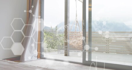 Naklejka premium Framing sliding glass door revealing deck with woven chair at home, showing sheer curtain overlays