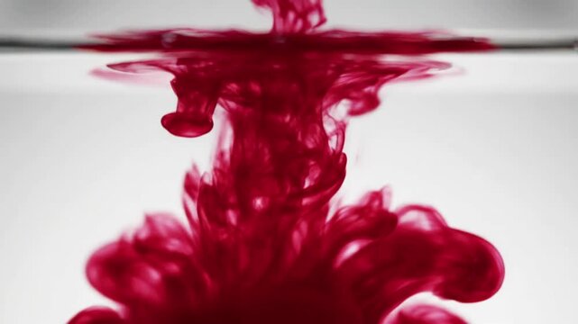 Crimson Ink Filaments Close-up of bold crimson ink gracefully spreading and extending delicate filaments, showcasing vivid edge diffraction at its interaction points with the liquid.