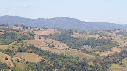 Deforestation on mountain slopes: bald hills, land clearance, and degradation causing air pollution, PM2.5 haze, global warming, and climate change in tropical agriculture.