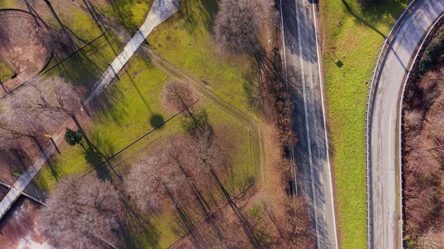 Aerial View of Parkway and Park: An eye-level perspective showcases a highway intertwining with a serene park, harmoniously coexisting to form an interesting pattern. 
