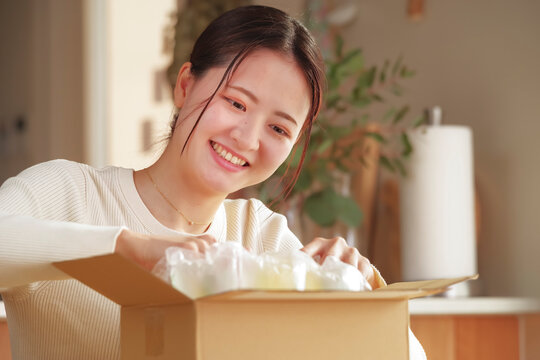 荷物を開封して嬉しそうな日本人女性