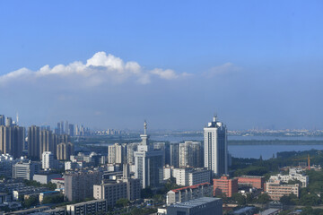 Fototapeta premium Modern Urban Skyline with Waterside Complexes Under Blue Skies