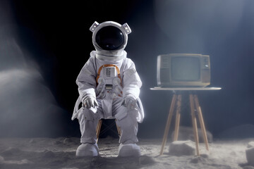Fototapeta premium Astronaut Sitting on Moon Watching Retro TV - Space Exploration Art