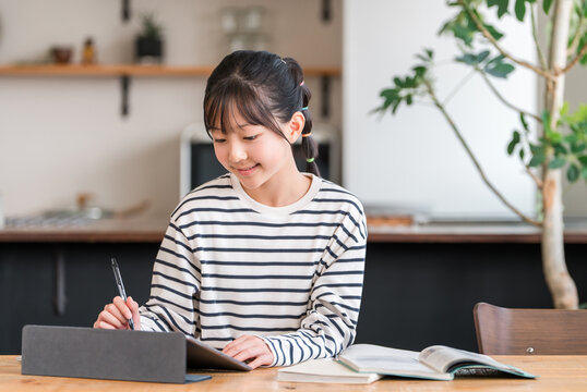 Elementary and junior high school girls studying and doing homework using tablets