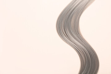 Obraz premium Grey hair strand on beige background