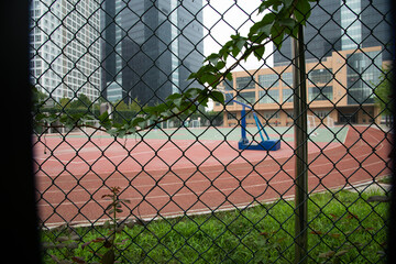 Beijing Urban Sports Ground Behind Chain-Link Fence with City Skyline © LeThi