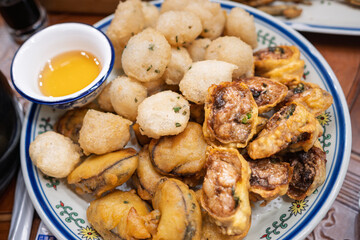 A Delicious Platter of Crispy Fried Oysters and Fish Balls Served with Dipping Sauce