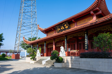 Obraz premium Traditional Chinese Temple with Red Walls and Curved Roofs Under a Clear Blue Sky