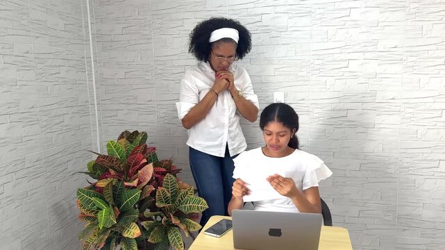 Joyful teenage girl celebrating with her mother after receiving good news in a college acceptance letter