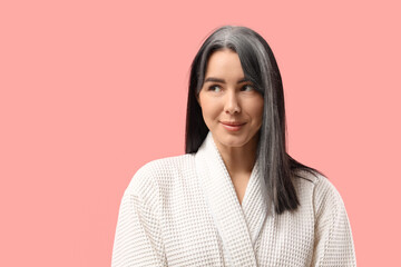 Obraz premium Young woman in bathrobe with graying hair on pink background