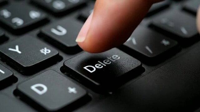 Finger Pressing Delete Key on Keyboard.