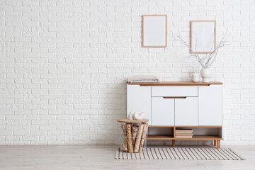 Interior of room with white commode, table and blank frames