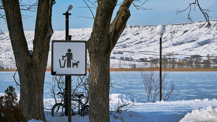 Dog Waste Sign at Frozen Lake in Winter