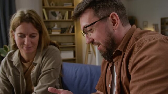 Close up shot of smiling man opening envelope and adult couple celebrating with high five after getting good news or banking letter while planning budget at home together, copy space