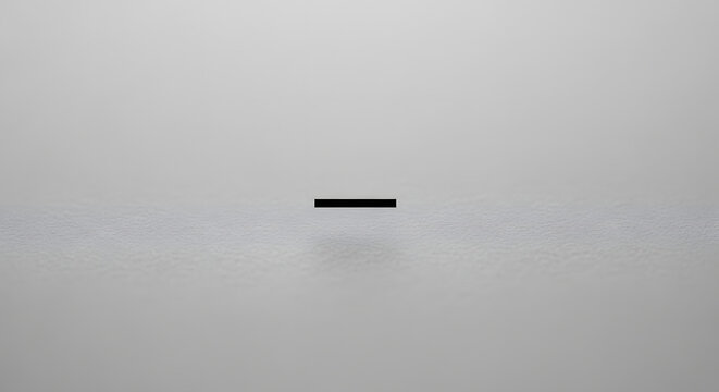 Simple black horizontal hyphen or dash symbol centered on a neutral grey surface