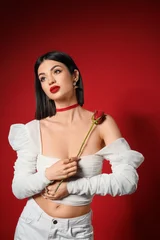 Fotobehang Onderzeeër Beautiful young elegant woman with rose on red background  © Pixel-Shot