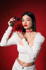 Fotobehang Onderzeeër Beautiful young elegant woman with rose on red background  © Pixel-Shot