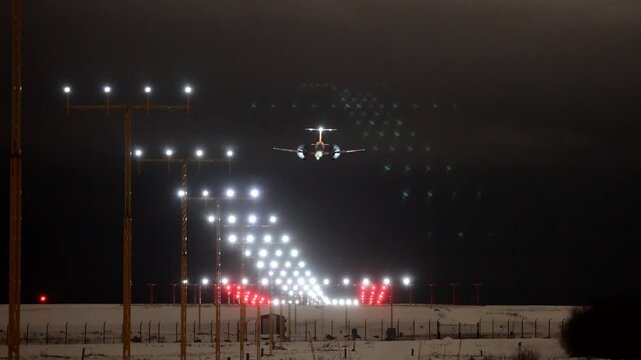 Stockholm, Sweden A plane lands at night in winter on a runway at Arlanda Airport.