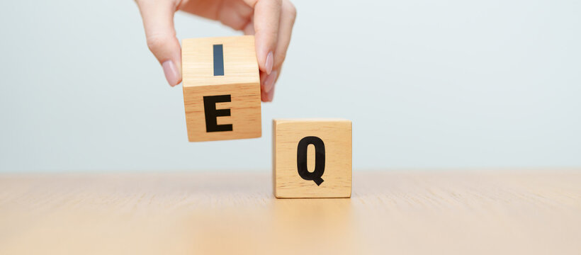 hand change wooden block from IQ to EQ, balance between intelligence quotient and emotional quotient, AQ Adversity, MQ, Moral, SQ and Social quotient concepts