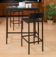 Modern Kitchen Interior Featuring a Height Dining Set, Black Elevated Table and Chairs, Contrasting Warm Wooden Cabinetry, with Lush Indoor Plant Accents, an Intimate and Functional Dining Nook.