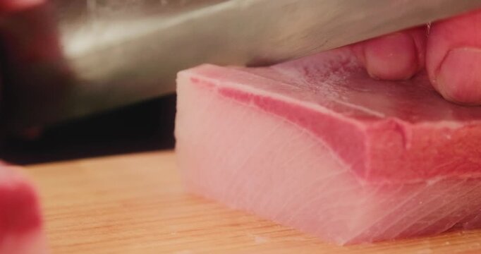 包丁で生のブリ・カンパチ・ハマチ魚の刺身を切り分ける寿司職人の手元　和食・日本料理のクローズアップ　魚介・海鮮料理　旅行・観光