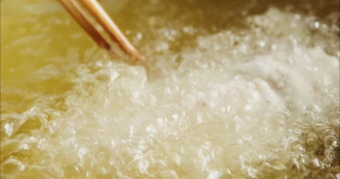 油で揚げるクローズアップ　魚の唐揚げ・天ぷら　和食・日本料理　泡立つ油のスローモーション　