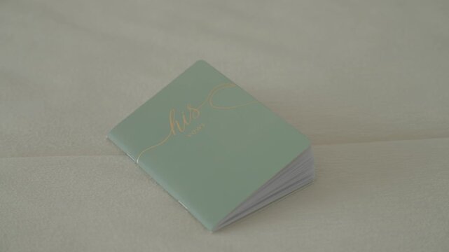 Close up of wedding vows booklet resting on white fabric