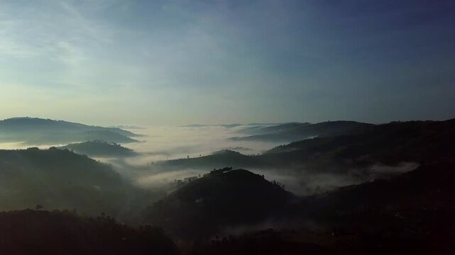 Kabale, Uganda mountain landscape at sunrise, foggy valley view with mist covering rolling hills and nature scene during morning light, aerial static