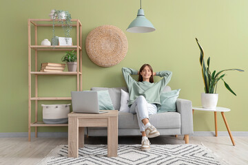 Pretty young woman sitting on sofa  at home