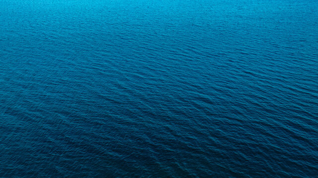 Top view of deep blue sea water surface with small ripples, aerial drone shot of turquoise ocean texture at island , abstract nature background 