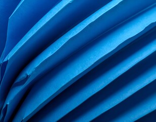 Abstract close-up of folded blue paper, showing textures and shadows