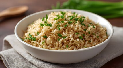 A white bowl of healthy brown rice garnished with fresh herbs presented on a rustic wooden table