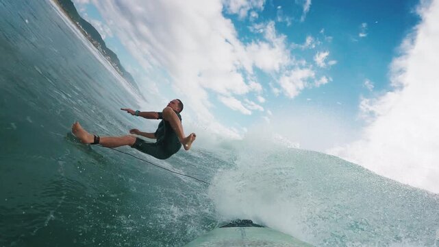 Surfer in wetsuit rides the wave in Atlantic Ocean. Surfboard camera view of the surf rider