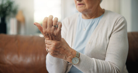 Elderly woman, hands and wrist pain with injury on sofa for carpal tunnel syndrome in home....
