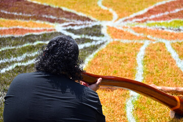 Indigenous Australians man play Aboriginal music with didgeridoo wind instrument