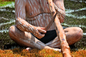 Indigenous Australians man play Aboriginal music with didgeridoo wind instrument