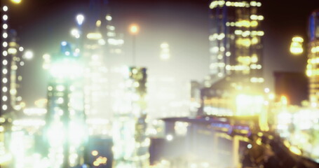 Obraz premium blurred urban night skyline glowing bokeh soft focus on distant towers and traffic, warm tones, dreamy atmospheric haze, modern architecture silhouettes, long