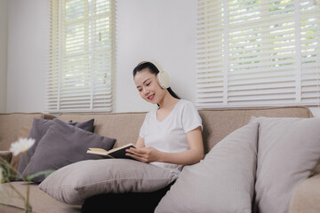 Fototapeta premium Asian woman resting on sofa at home with dog, feeling unwell yet peaceful, dreaming, bonding, comfort, wellness, quiet daytime lifestyle. 