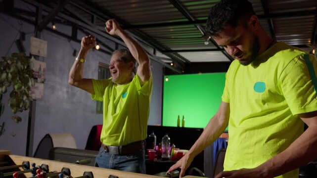Father celebrating goal while son checks phone