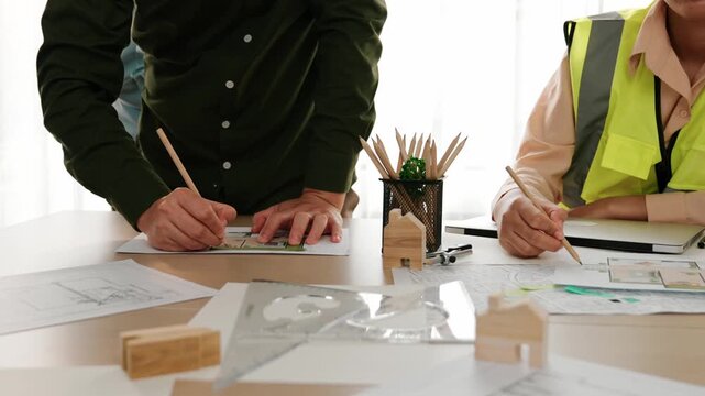 Professional engineer measuring the blueprint. Professional engineer working architectural project at studio on a table with yellow helmet and architectural equipment scatter around. Delineation.