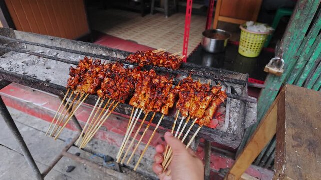 close-up of satay chicken grilled over charcoal